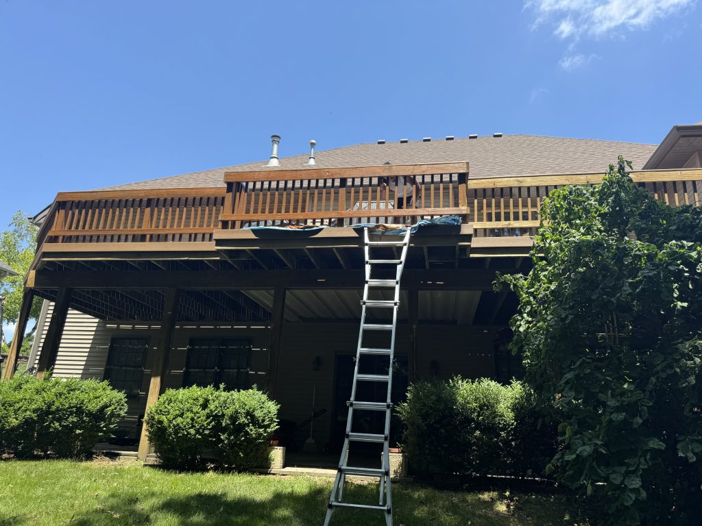 Deep brown stained deck structure with a ladder set up during a staining project by TD Surface Stain and Seal