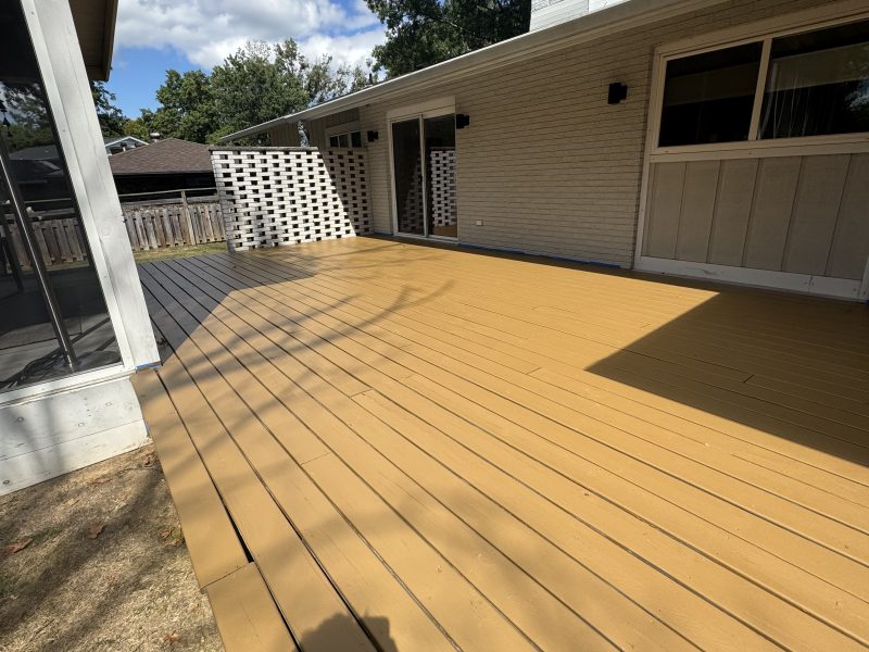 Natural-toned stained deck with curved edge alongside a mid-century modern home, hand-applied finish by TD Surface Stain and Seal