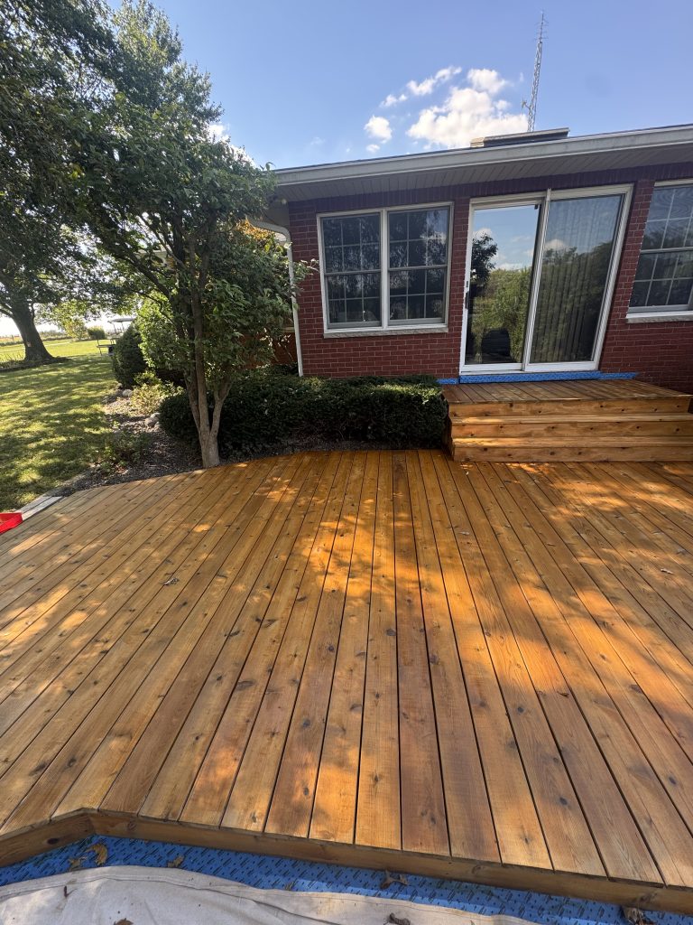 Beautiful cedar-toned stained deck at a brick home with steps and landscaping, hand-applied by TD Surface Stain and Seal Springfield IL