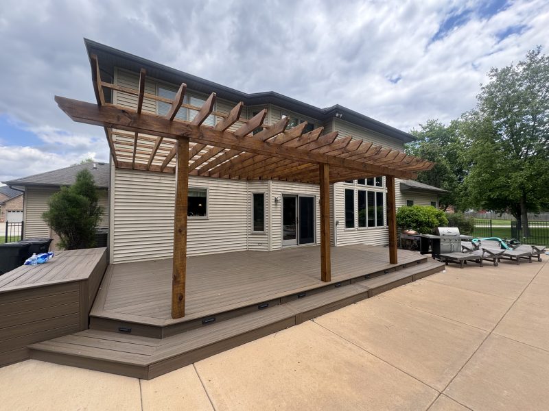 Large multi-level deck with wood pergola alongside an inground pool, hand-applied light-tone stain finish by TD Surface Stain and Seal, Springfield IL