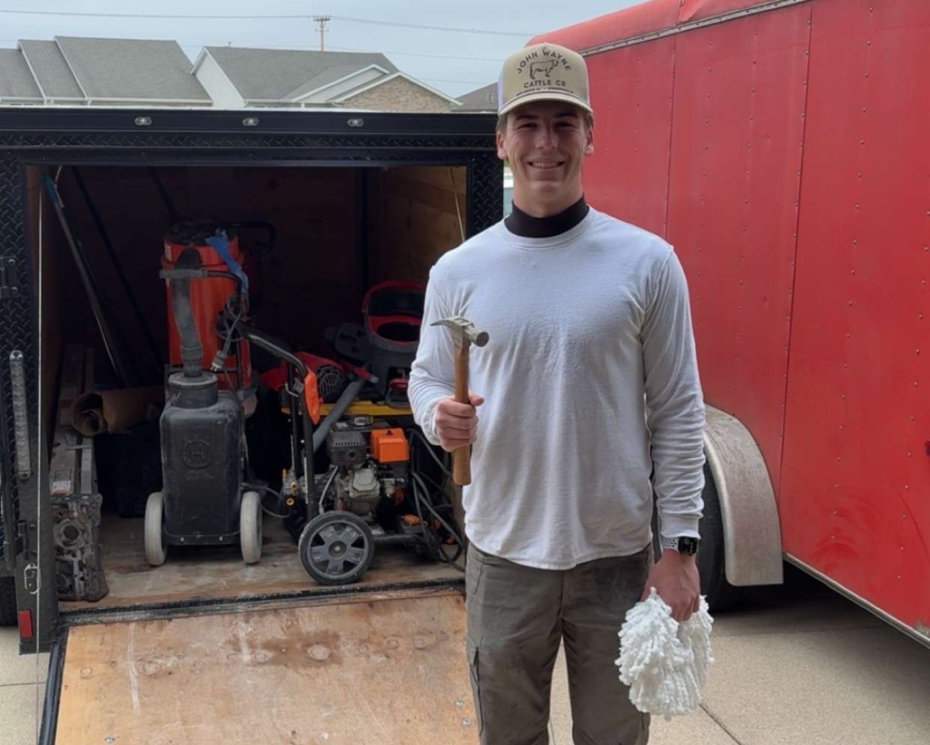 Trystin Decatoire, owner of TD Surface Stain and Seal, standing at the TD Surface trailer with prep equipment in Springfield IL